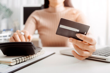 Business people use tablets and hold credit cards as an online shopping concept With a calculator and a book placed on the table