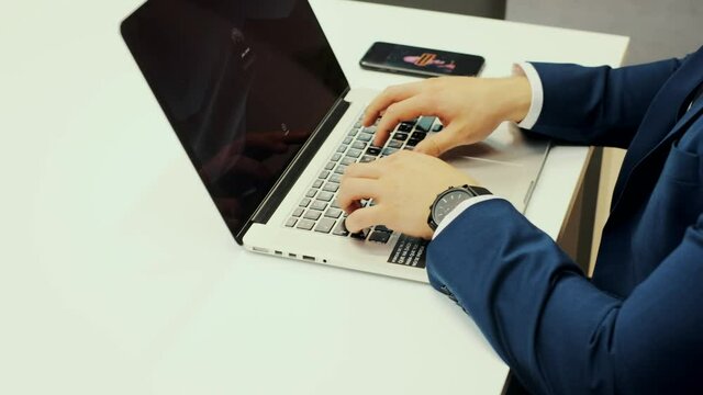 chico feliz joven escribiendo en el portatil mientras esta sentado en salon luminoso en un moderno apartamento