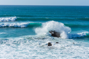 General shot of waves on rocks on the beach of Liencres, in Cantabria, Spain, horizontal