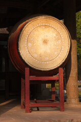 Red wooden drum on frame at entrance to Buddhist temple in Vietnam