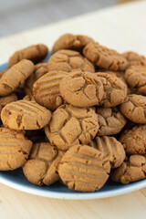 Very tasty peanut butter biscuits on bamboo light brown wooden board, golden baked healthy
