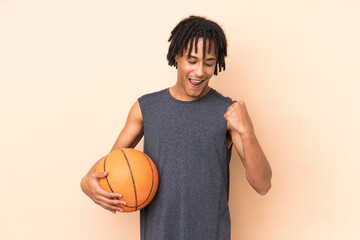 Young african american man isolated on beige background playing basketball