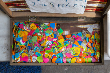 Group of colorful guitar picks with themed textures in a backgammon board on a street stall in Istanbul.