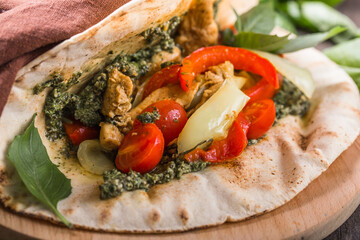 Fajitas with tortilla mix pepper, basil and pesto on wooden board