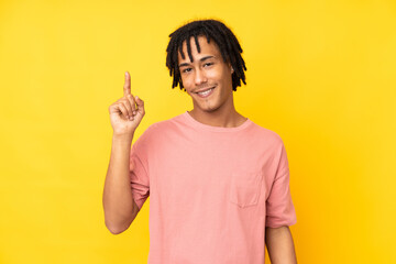 Young african american man isolated on yellow background showing and lifting a finger in sign of the best