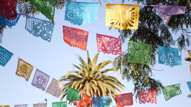 Colorful mexican perforated papel picado banner, festival colourful paper garland. Multi colored hispanic folk carved tissue flags, holiday or carnival. Authentic fiesta decoration in Latin America.