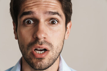 Fototapeta premium Image of scared businesslike brunette man expressing surprise on camera