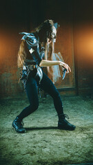 Dancing post apocalyptic woman warrior in armor with the knife.