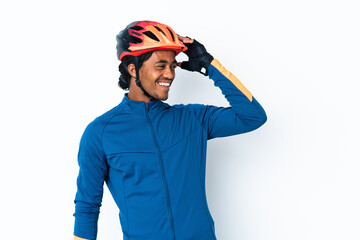 Young cyclist man with braids over isolated background smiling a lot