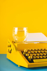 Yellow bright typewriter on a yellow background. Creativity concept