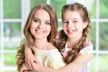 Portrait of a charming little girl with mom at home