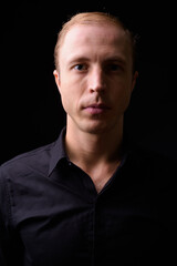 Businessman with blond hair against black background