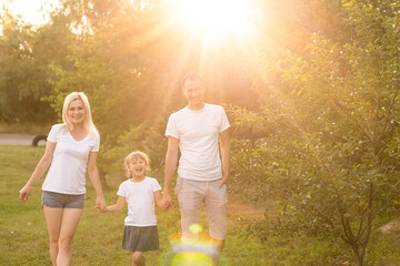 Fototapeta na wymiar Family bonds. Happy young family of three smiling while spending free time outdoors