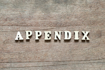 Alphabet letter block in word appendix on wood background