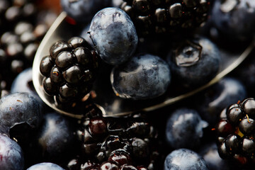 blueberry and blackberry on spoon