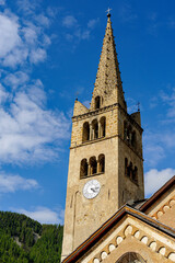 Fototapeta na wymiar Typical church of the Hautes-Alpes. The bell tower is entirely built of local stone. The dial of a clock allows the whole village to know the time.