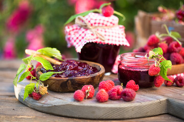 Fresh raspberries jam with fresh raspberries on natural garden. Selective focus