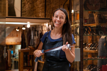 Female leather artisan in front of her shop and workshop