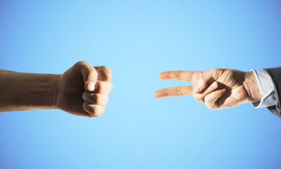 Two hands fist and victory sign on blue background.