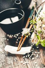 Chinese Tea Set, chopsticks and sakura branch on rustic wooden table