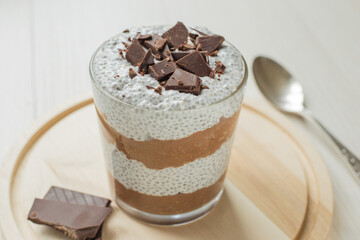 Chocolate pudding with coconut milk and chia seeds in glass close-up. Clean eating and super foods concept.  