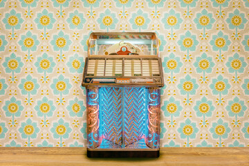 Colorful vintage jukebox in front of retro flower wallpaper