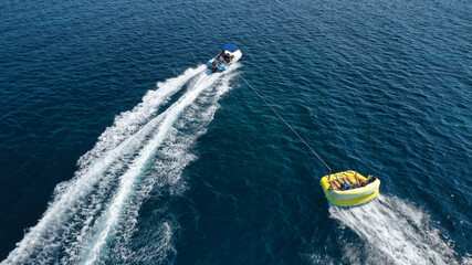 Aerial drone tracking photo of extreme power boat donut water-sports cruising in high speed in open ocean deep blue bay