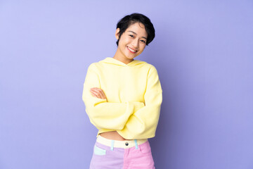 Young Vietnamese woman with short hair over isolated purple background keeping the arms crossed in frontal position