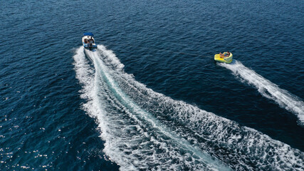 Aerial drone tracking photo of extreme power boat donut water-sports cruising in high speed in open ocean deep blue bay