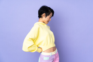 Young Vietnamese woman with short hair over isolated purple background suffering from backache for having made an effort