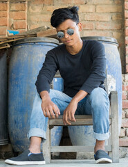 Portrait of a teenager young boy wearing black shirt with sunglasses and looking another side