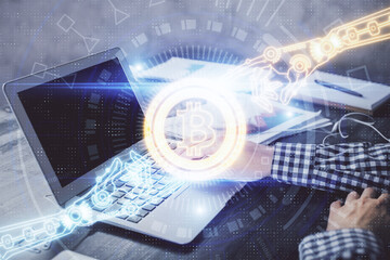 Blockchain theme hologram with man working on computer on background. Concept of crypto chain....