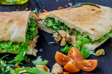Gyros style Greek chicken sandwich in grey wooden old rustic board