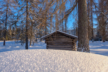 Wooden hut in deep fresh snow 