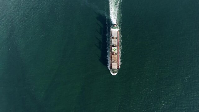 Top down aerial footage of a Cargo ship cruising in Hong Kong bay.