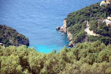 Spectacular panoramic view of Palaiokastritsa village and beach with its harbor during the midday on. Corfu, Greece.