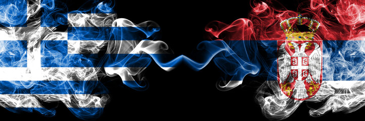 Greece vs Serbia, Serbian smoky mystic flags placed side by side. Thick colored silky abstract smoke flags.