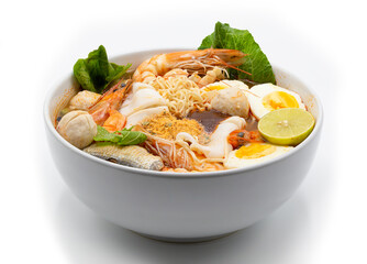Tom yum kung or hot and spicy shrimp soup boiled with noodle and ingredient inside, in the white bowl.