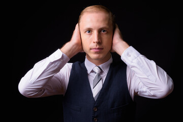 Businessman with blond hair against black background