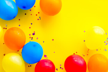 Party concept with colorful balloons on yellow background top view copy space