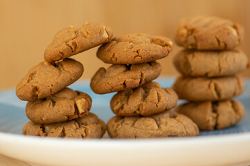 Very tasty peanut butter biscuits on bamboo light brown wooden board, golden baked healthy