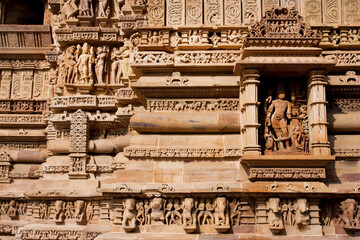 Stone walls with artworks and sculptures of Khajuraho, India. Artifacts in old temple, from 10th century, with historical people, ancient life.