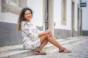 Fototapeta premium Beautiful woman sitting on the pavement