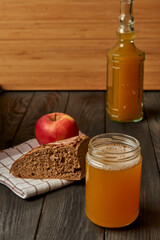 Kvass drink in a glass jar on an old wooden board with rye bread 