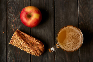 Kvass drink in a glass jar on an old wooden board with rye bread 