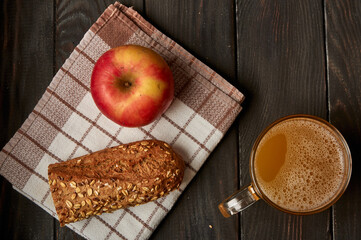 Kvass drink in a glass jar on an old wooden board with rye bread 