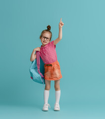 Kid with backpack on color background.