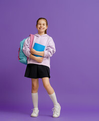 Kid with backpack on color background.