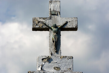 Stary krzyż na cmentarzu na tle nieba