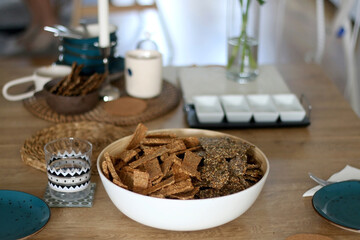 Two types of seed crackers, served in a big bowl on a table. Selective focus.